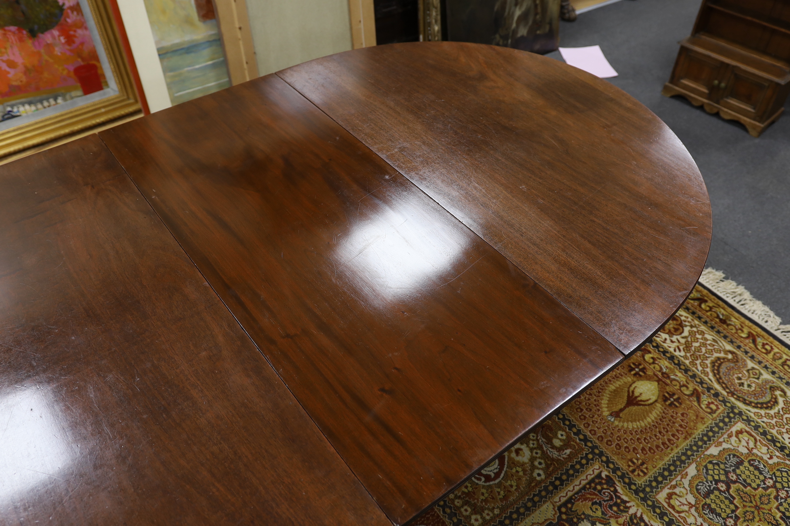 A George III style mahogany triple pillar D end extending dining table in the manner of Gillows